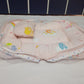 Baby crib with colorful bedding and pillows against a tiled wall.