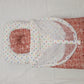 Red and white baby outfit with colorful polka dots on a light gray background